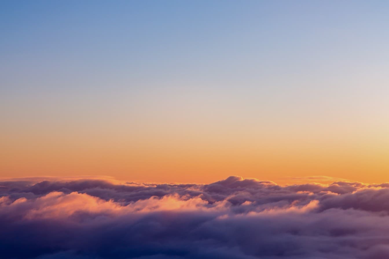 A sunset glowing above a sea of clouds