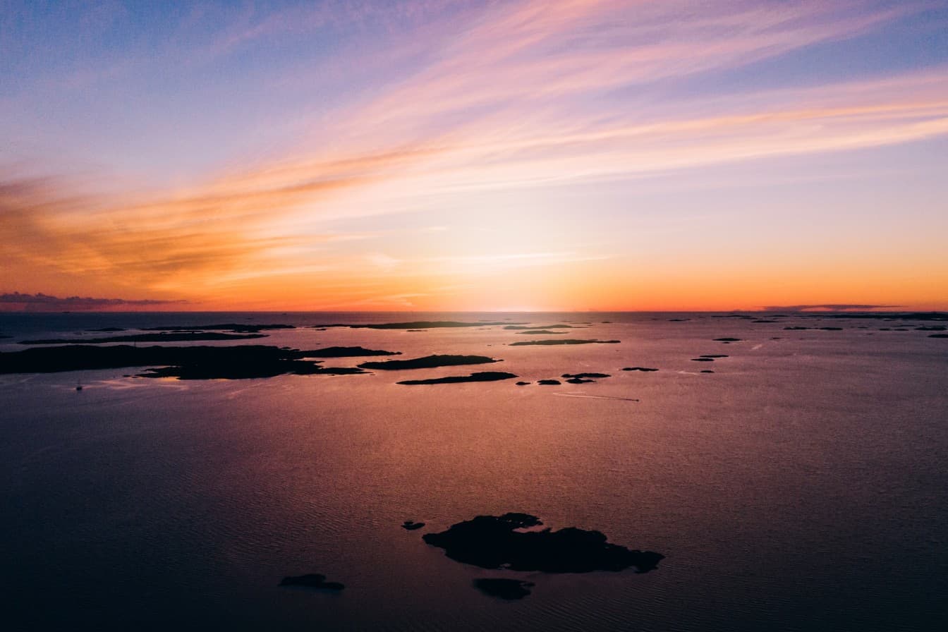 Sunset over calm water dotted with small islands